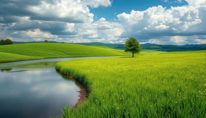 Obraz premium a view of a green field with a river running through peaceful landscape