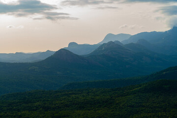 Peaceful scene of mountains and forests under a cloudy evening sky