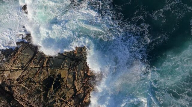 Waves Crashing On Rocky Shore. aerial topdown, slow motion