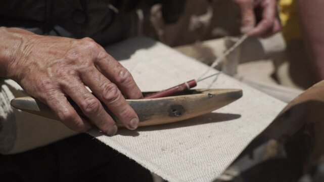 close-up views of hands manipulating an old antique traditional wooden loom in Ladakh, India