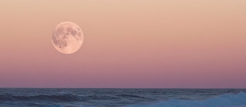 Serene full moon illuminating the evening sea horizon with pastel sunset colors reflecting on tranquil waters