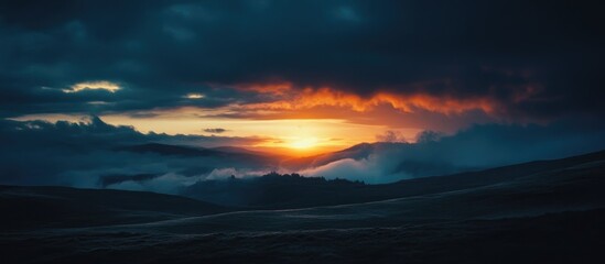 Fototapeta premium Majestic sunset over mountain ridges with dramatic clouds and vibrant colors illuminating the sky and valley below.