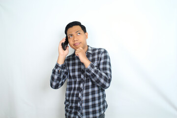 clueless asian man talking on smartphone with confused face expression isolated on white background