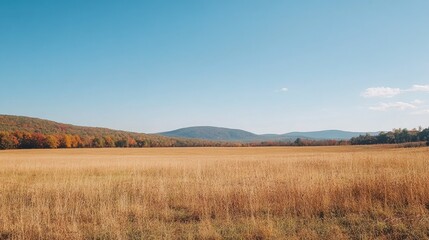 Stunning autumn landscape with golden fields and vibrant mountains under a clear blue sky showcasing nature's seasonal beauty