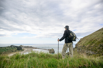 Man hiking the Deliverance Cove track. Castlepoint. Wairarapa. New Zealand.