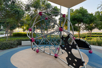 modern children playground with a climbing, surrounded by lush greenery and trees