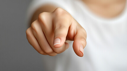 woman’s index finger pointing directly at the viewer conveying confidence, engagement, and a sense of direction with a clean and sharp focus on her gesture