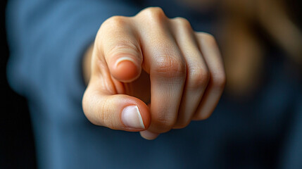 woman’s index finger pointing directly at the viewer conveying confidence, engagement, and a sense of direction with a clean and sharp focus on her gesture