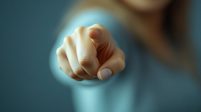 woman’s index finger pointing directly at the viewer conveying confidence, engagement, and a sense of direction with a clean and sharp focus on her gesture