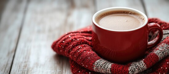 Cozy red cup of hot cacao on Scottish plaid fabric with wooden table backdrop and decorative beads ideal for holiday or winter-themed designs
