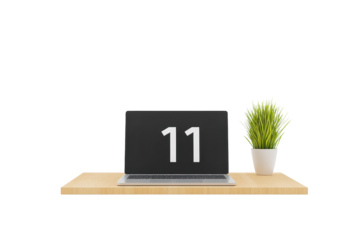 A modern laptop displaying the number 11 on a wooden desk, accompanied by a small potted plant.