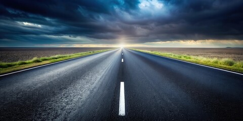 Naklejka premium A solitary asphalt road cutting through a field, leading towards a horizon illuminated by a sun peeking through dark storm clouds