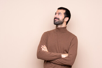 Obraz premium Man over isolated background looking up while smiling