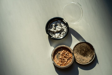 Broken palettes with bronzer and powder on a white table. Decorative cosmetics