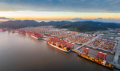 Aerial view of container port and seaside natural scenery at sunrise