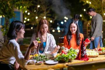 A group of women are sitting around a table eating food and laughing