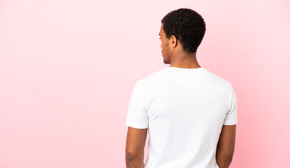 African American man on copyspace pink background in back position and looking side