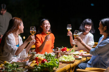 A group of women are sitting around a table with food and drinks