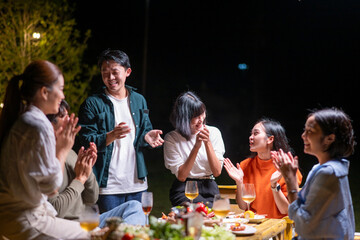 A group of people are gathered around a table, enjoying a meal together