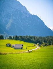 Schöne Berg Straße in Mittenwald Deutschland Alpen. Panorama Sicht auf Feld, Gebirge und Wiese.  See Idylle wandern durch Wald und Natur. 
Beautiful mountain road in Germany alps. Panorama view field