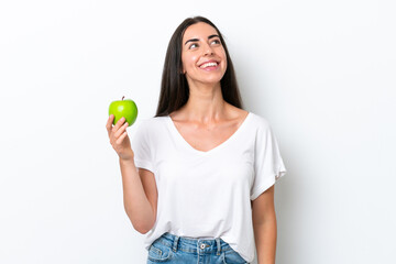 Young caucasian woman isolated on white background looking up while smiling