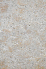 Light beige travertine stone wall with marbled texture as vertical background