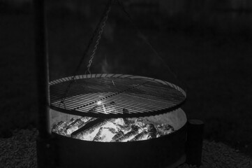Rozpalony grill ogrodowy tlący się ogień, czarno-biale zdjecie © Paweł Kacperek