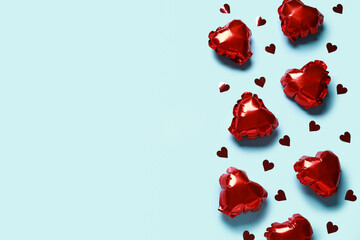 Red heart shaped air balloons and confetti on blue background