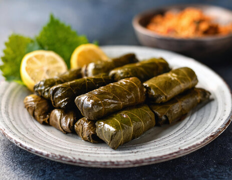 Delicious Turkish sarma (dolma) stuffed grape leaves, rice, served with lemon wedges