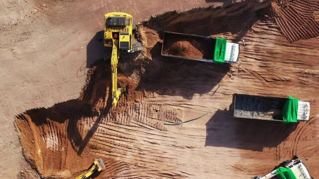 Aerial view road motor grader flatting dirt road surface, Motor grader road construction grader industrial machine construction site new road, Aerial view group excavator working on construction site.