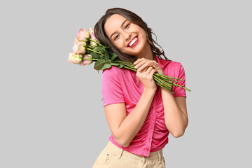Pretty young woman with bouquet of beautiful roses on grey background. Valentine's Day celebration