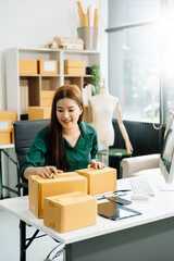 Business owner woman prepare parcel box and standing check online orders for deliver