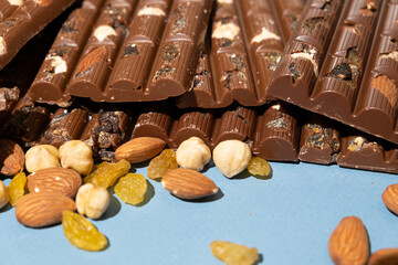 Lots of chocolate bars with nuts and raisins on a blue background
