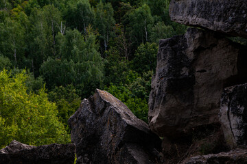 Majestic rock formations rise from the earth as vibrant trees envelop the landscape, creating a serene atmosphere.
