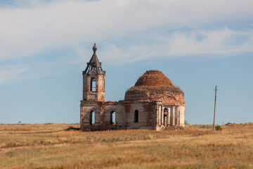 Historic church ruins display intricate architecture in rolling fields beneath a vibrant blue sky,...
