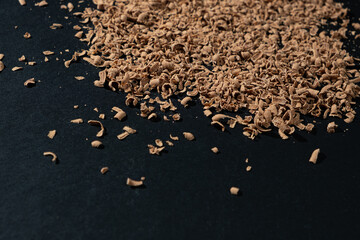 Grated natural organic chocolate shavings on a black background