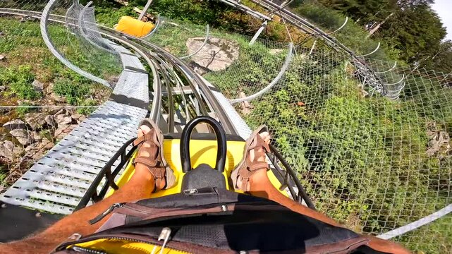A person is riding a roller coaster with a yellow backpack on