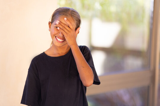 aboriginal girl child face palming in black tee shirt with blurred background