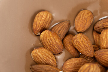 Almond nuts in melted milk chocolate macro