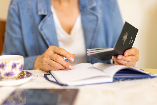 anonymous elderly person making travel plans holding a passport