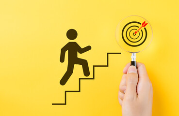 Success and goal achievement concept. A person climbing stairs toward target in a magnifying glass, progress, determination, and goal achievement in personal or business contexts. Steps for goal,