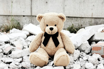 plush bear sitting on rubble in urban environment