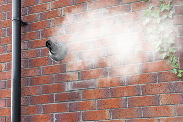 Condensing Gas Boiler Flue Steam Vapor Emitted from Black Pipe on Red Brick Wall against Blue Sky