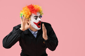 Surprised young man as clown policeman showing eavesdrop gesture on pink background