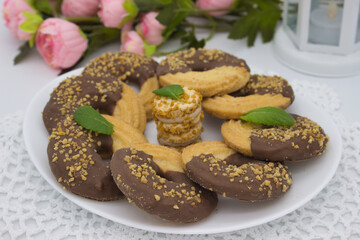 Coffee with chocolate cookies and mint on white lace decor