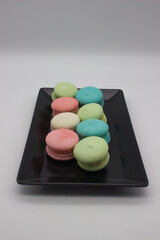 Colorful macarons arranged on black plate