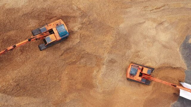Aerial view road motor grader flatting dirt road surface, Motor grader road construction grader industrial machine construction site new road, Aerial view group excavator working on construction site.