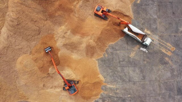 Aerial view road motor grader flatting dirt road surface, Motor grader road construction grader industrial machine construction site new road, Aerial view group excavator working on construction site.