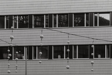 Decorative spheres hang in front of a modern building showcasing architectural design during the day