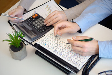 Young businessmen, a girl and a guy, work in the office on drawing up an annual report. Hands close-up.